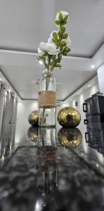 a vase with a white flower sitting on a table at Bilene Harmony Home in Vila Praia Do Bilene +12 photos