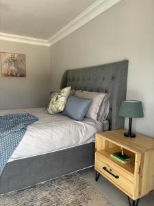 a bedroom with a bed and a night stand with a lamp at Sebeshong Guest House - Moletjie in Ga-Komape