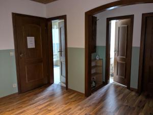 an empty room with two doors and wooden floors at Pension Heller in Odelzhausen +10 photos