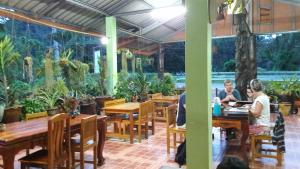 a group of people sitting at tables in a restaurant at Khao Sok Holiday Resort in Khao Sok National Park