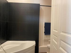 a bathroom with a white toilet and a black wall at Maison Léopoldine 1 , Quartier Historique in Blois