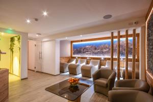 a living room with a couch and chairs at Hotel Denny in Pinzolo