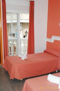 um quarto com duas camas e uma janela em Hostal Mary Tere em Salobreña