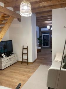 a living room with a tv and a wooden ceiling at Casa das Andorinhas - AL in Castelo de Vide