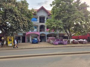 a building with purple chairs on the side of a street at G and E Guesthouse in Kumba