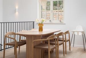 a wooden table with chairs and a vase with flowers at Casa Sorelle secluded villa with breathtaking pool in Seline