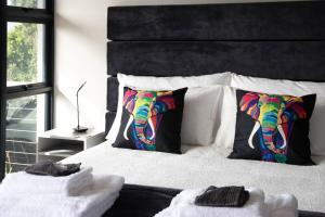 a bedroom with a bed with a colorful elephant pillow at Number 1 at SuPaViews in Wilderness
