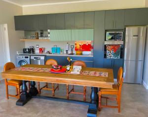a kitchen with a wooden table with chairs and a refrigerator at Number 1 at SuPaViews in Wilderness +26 photos