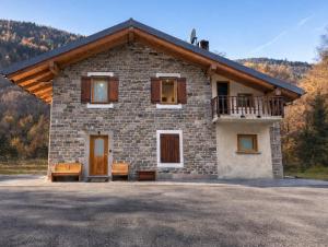 a stone house with two benches in front of it at Al Vagone in La Salle