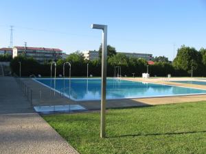 a light pole in the grass next to a swimming pool at My Home in OPorto in Maia