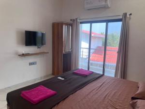 a bedroom with a bed with two pink towels on it at Nisarg Forever Resort in Jāmb