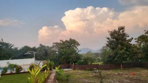 a view from the backyard of a house with trees at Nisarg Forever Resort in Jāmb +3 photos
