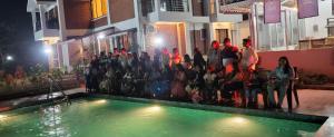 a group of people standing next to a swimming pool at Nisarg Forever Resort in Jāmb