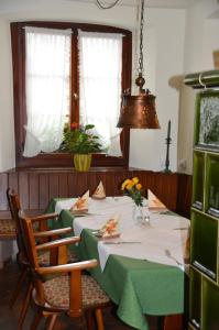 a dining room with two tables and chairs with flowers at Gasthof Engel in Dottingen