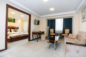 a hotel room with a bed and a living room at Sayohat Hotel in Tashkent