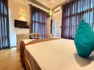 a bedroom with a bed with a pillow on it at Hotel Catamaran Bay by Ayur Ayur in Negombo