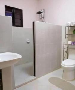 a white bathroom with a toilet and a sink at Villareal Homestay in Coron +39 photos
