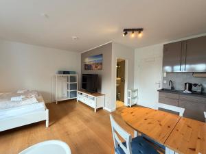 a kitchen and dining room with a table and a bed at Beachfront Studio - 1 Strandreihe in Scharbeutz +2 photos