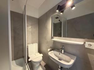 a bathroom with a toilet and a sink and a mirror at Beachfront Studio - 1 Strandreihe in Scharbeutz