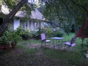 two chairs and a table in front of a house at Le clos des mûriers in Hautot-sur-Mer