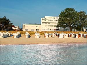 a group of chairs on a beach next to the water at Beachfront Studio - 1 Strandreihe in Scharbeutz