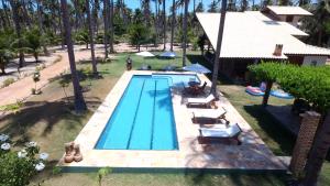 vista sulla piscina con sedie a sdraio di Casa de Temporada Muricis a Guajiru