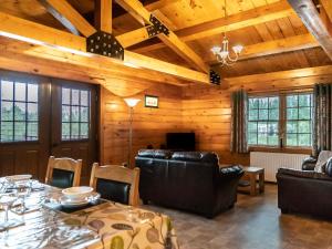 a living room with a table and leather furniture at Lake View Lodges - 25076 in Old Leake