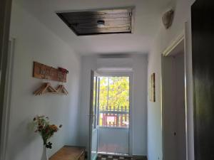 a hallway with a door and a window and a table at Szemben apartment in Csengőd