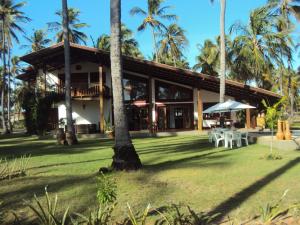 a house with palm trees in front of it at Casa de Temporada Muricis in Guajiru