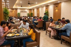 a group of people sitting at tables in a restaurant at Shahenshah Hotel in Civil Lines, Prayagraj in Prayagraj