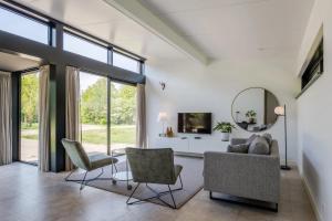 a living room with a couch and chairs and a mirror at Landal Olde Kottink in Beuningen
