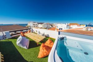a balcony with a picnic table and a swimming pool at Balili Surf House in Baleal