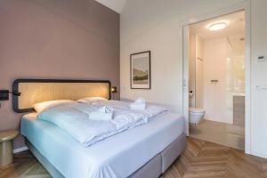 a bedroom with a large bed and a bathroom at Landal Olde Kottink in Beuningen
