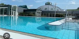 a large swimming pool with a building in the background at Ferienwohnung Stefanie OG in Bad Breisig