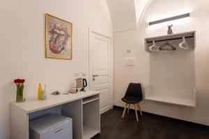 a small white kitchen with a desk and a chair at La Dama del Castello in Bosa