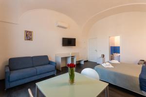 a living room with a bed and a couch and a table at La Dama del Castello in Bosa