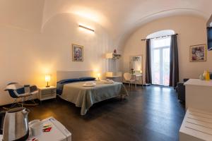a room with a bed and a table and chairs at La Dama del Castello in Bosa