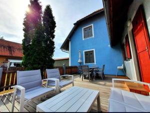a patio with chairs and a blue house at Terme Čatež - Family apartments with pool tickets in Čatež ob Savi +25 photos