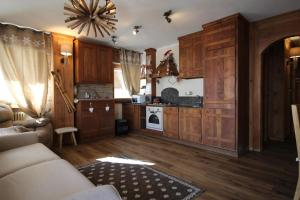 a kitchen with wooden cabinets and a living room at Rifugio nella neve in Sestriere