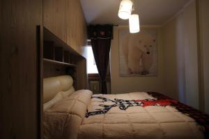a bedroom with a bed with a teddy bear on the wall at Rifugio nella neve in Sestriere