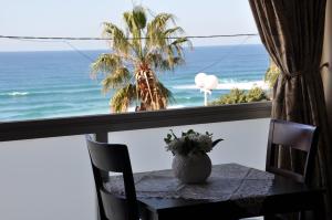 a table with a view of the ocean from a balcony at Hotel Suites Bat Yam in Bat Yam