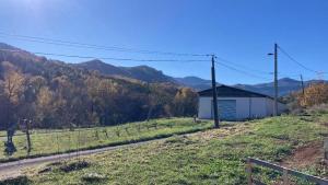 a field with a fence and a building on a hill at Au pied du plateau in Campagne-sur-Aude