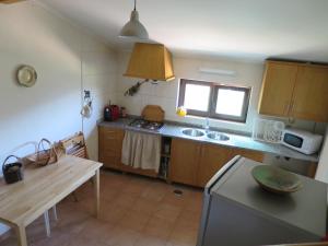 eine Küche mit einem Tisch und einer Arbeitsplatte in der Unterkunft Casa das Oliveiras in Colmeal