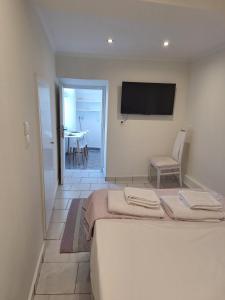 a bedroom with a bed and a television on the wall at Perla in Pythagoreio