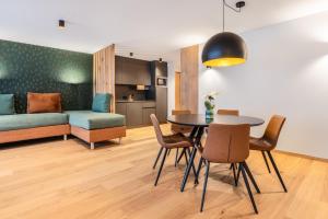 a living room with a table and chairs and a couch at Ciasa Milandura NEW SUMMER 2025 in San Cassiano