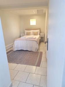 a bedroom with a large bed with white sheets at Perla in Pythagoreio