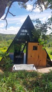 a pyramid shaped building with a tub in the middle at Chalé estrela de ouro in Alexânia +11 photos