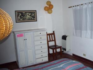 1 dormitorio con 1 cama, vestidor y silla en Casa Abedules de los Andes en San Martín de los Andes