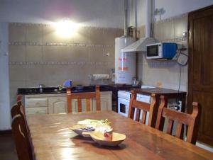 cocina con mesa de madera con sillas y mesa en Casa Abedules de los Andes en San Martín de los Andes