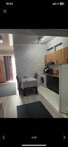 a small kitchen with a table and a microwave at Likefront Apartment Issyk-Kul in Bosteri